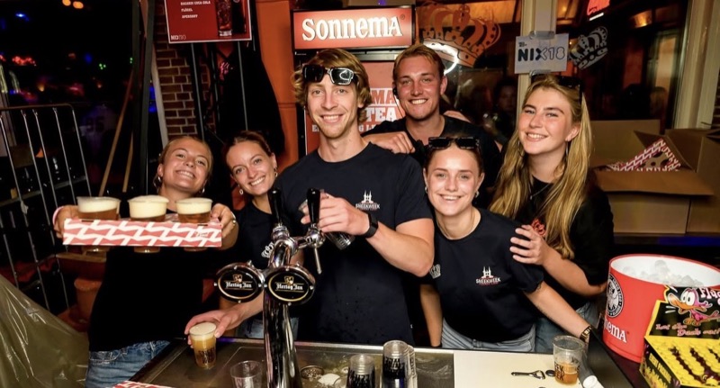 Het barteam achter de tap met een blad vol bier