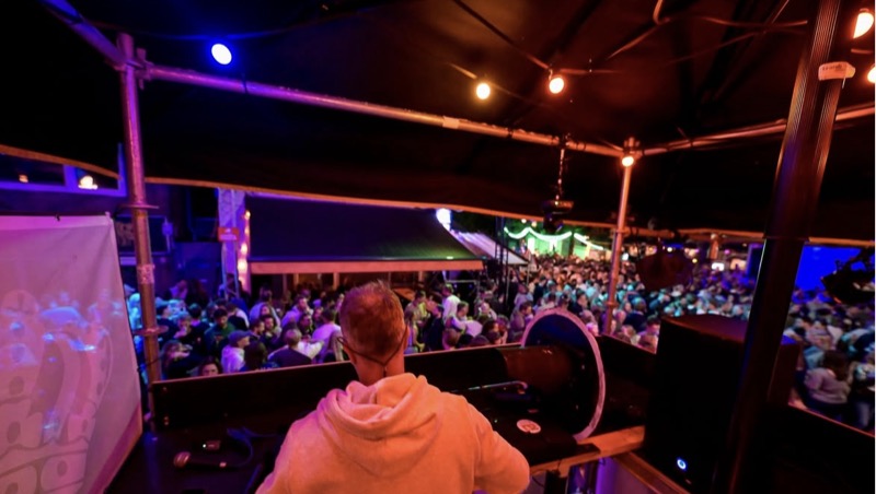 De dj kijkt uit over een volle zaal