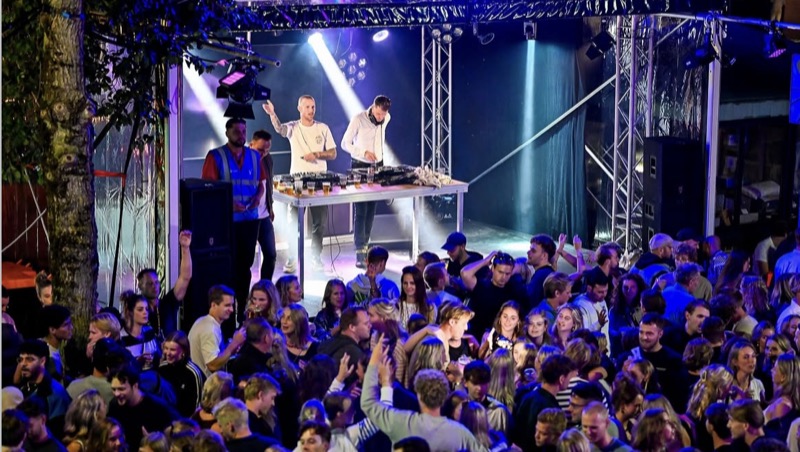 Dj's op het podium met handen in de lucht