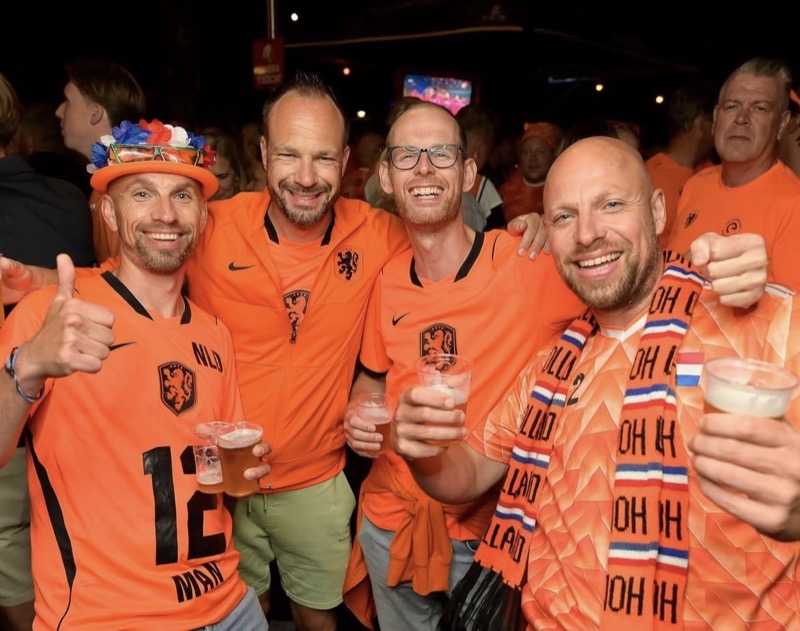 Supporters in oranje shirts met een biertje
