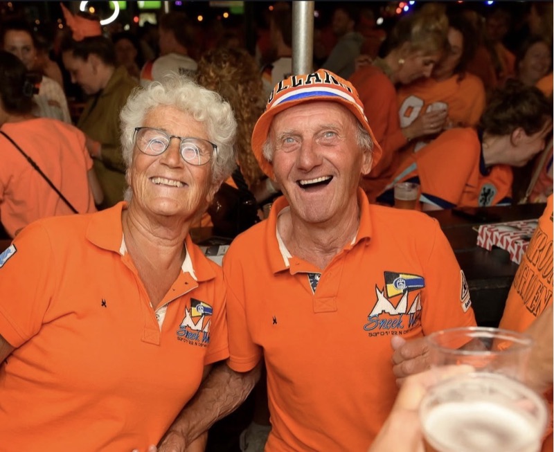 Ouder stel in oranje proost tijdens het WK